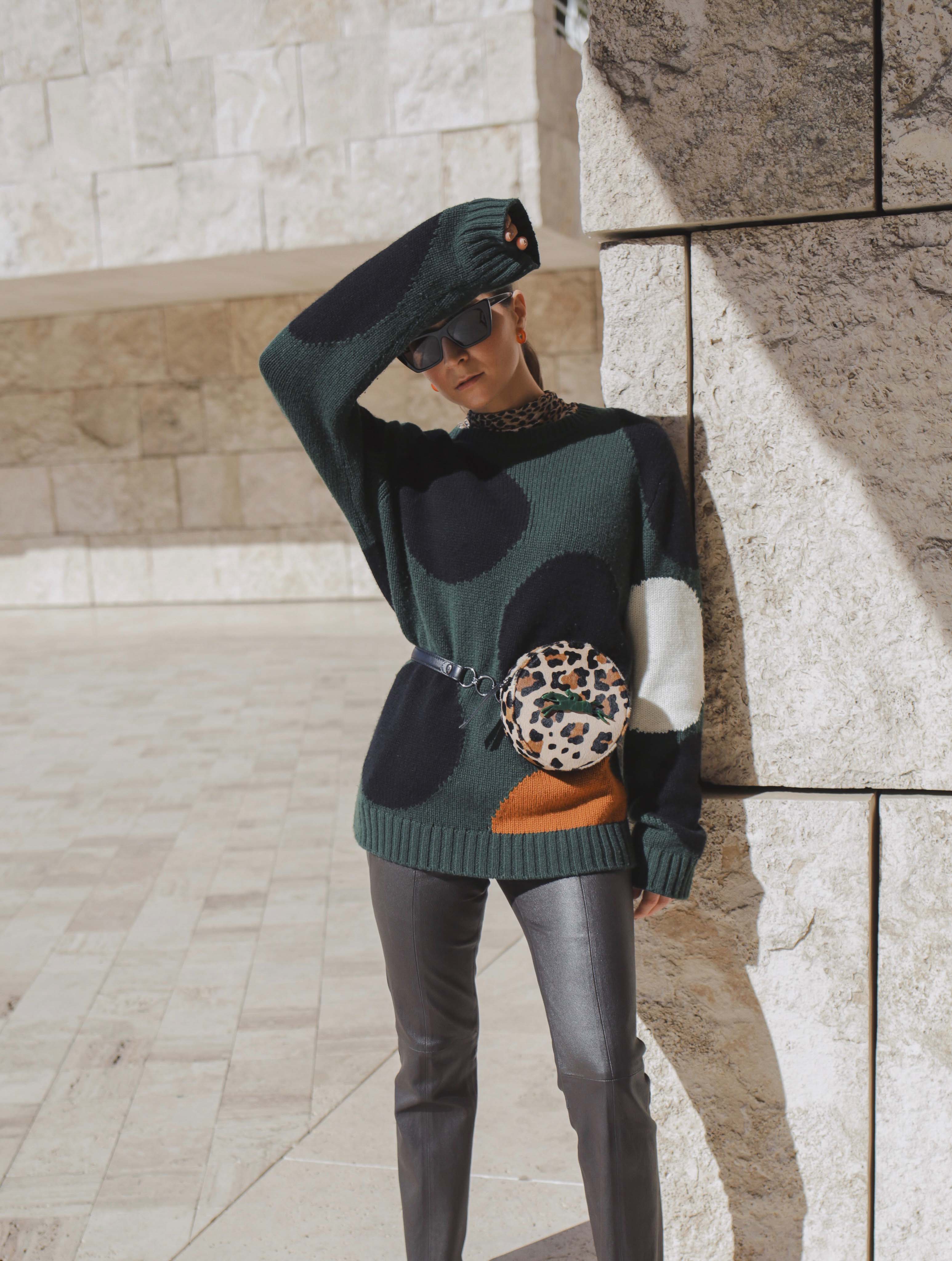 Winter style: arty swearter Chinti & Parker, Longchamp belt bag (similar here), Leopard turtleneck top Rag Doll LA, Equipment brown leather pants, Glass hoops Wolf Circus, AGL leopard ankle boots, Jeanne Shoulder Bag in brown by Yuul Yie. Getty center, fashion photography, fashion editorial, fashion photoshoot