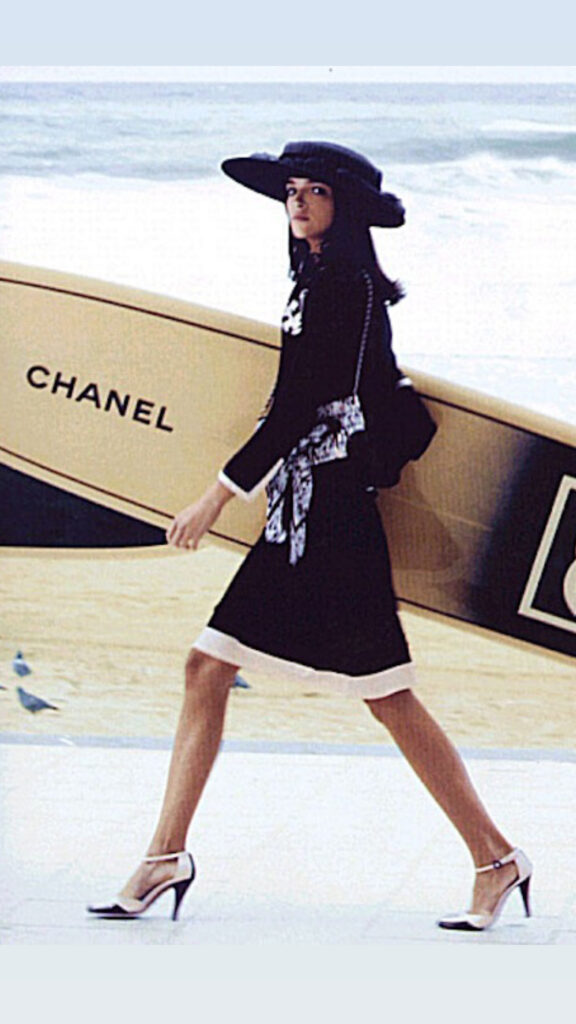 CHANEL SS 2003 campaign shot by Karl Lagerfeld with Mariacarla Boscono with a Chanel suit and a surf board